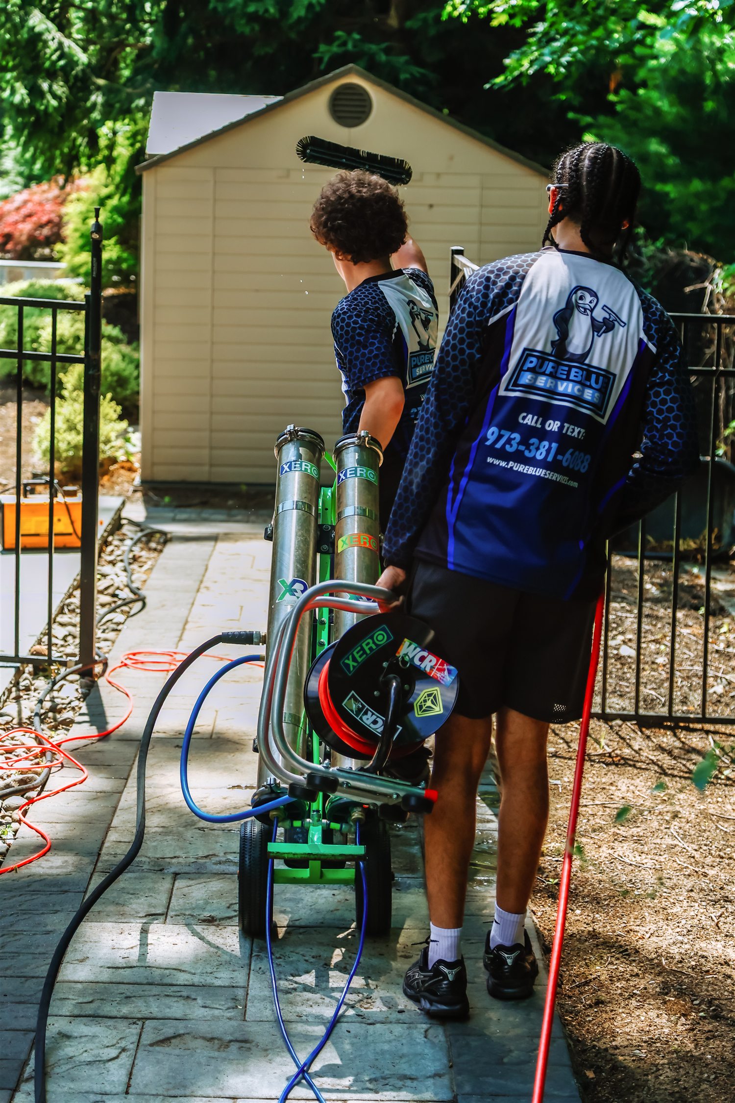 Pure Blue team operating professional exterior-cleaning equipment