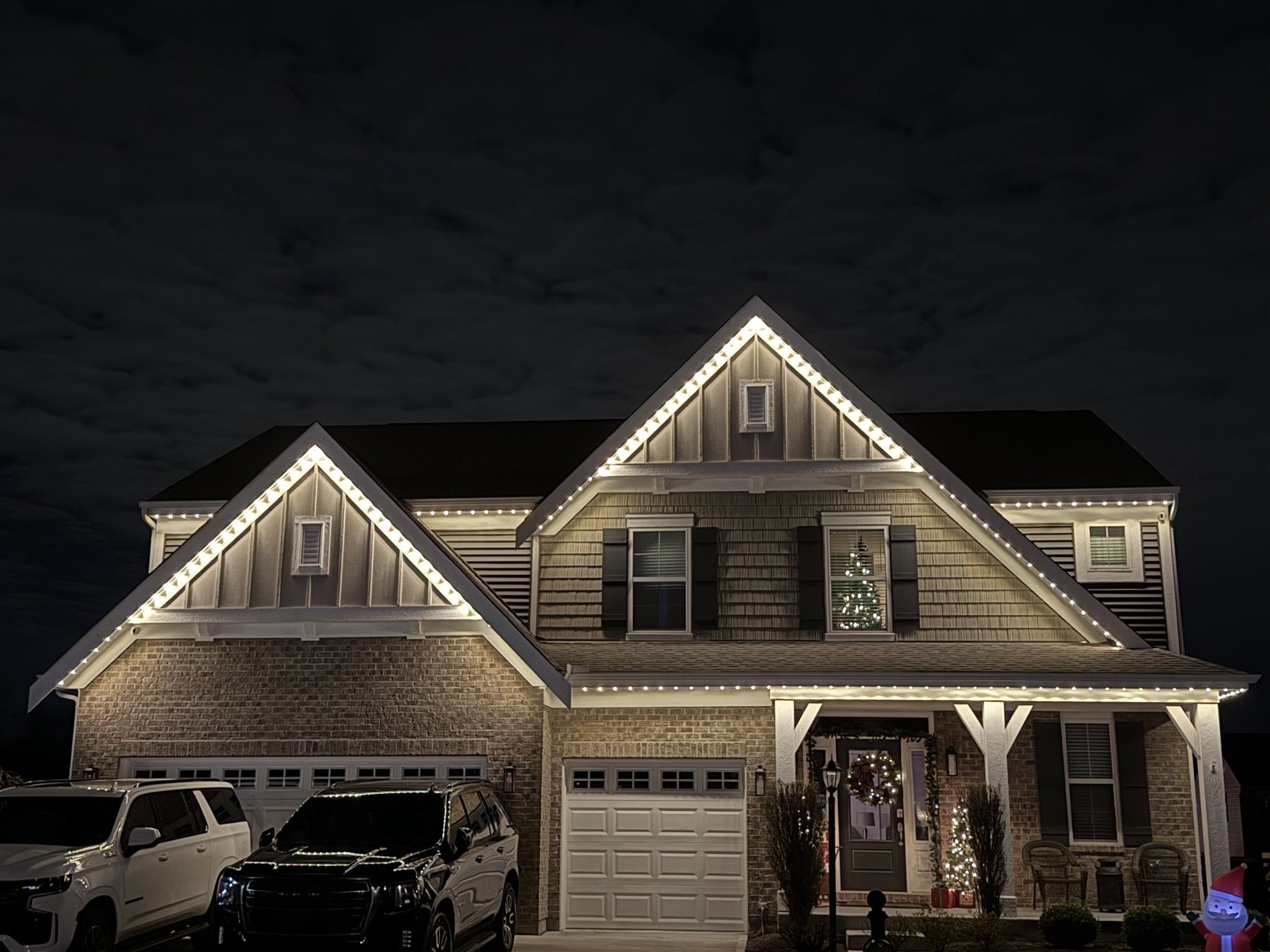 Warm white holiday lighting professionally installed along a home roofline