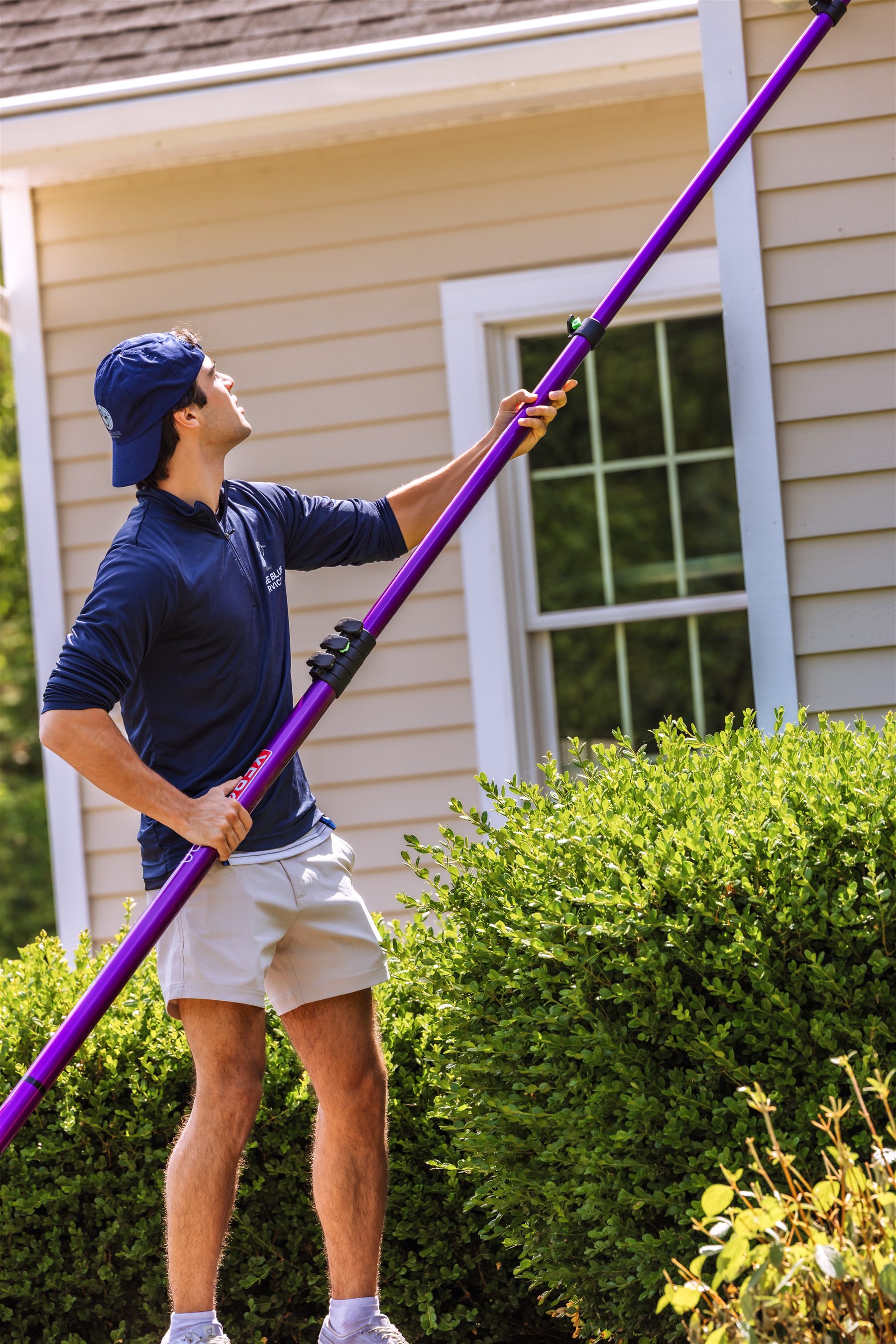 Pure Blue technician professionally cleaning exterior windows