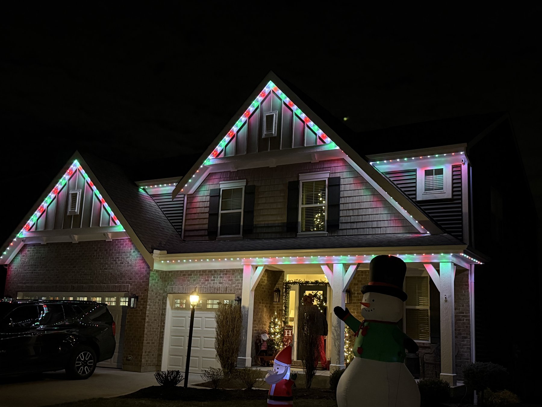 Red, green, and white holiday lights on a completed residential installation