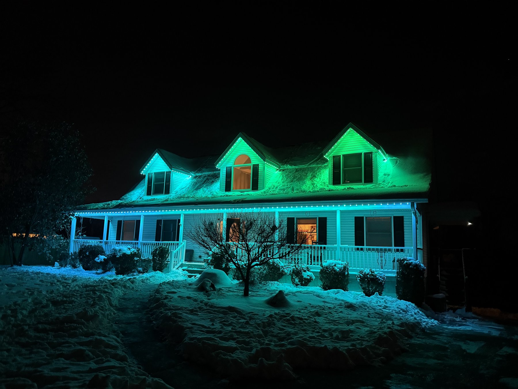 Permanent exterior lights illuminating a home in blue and green