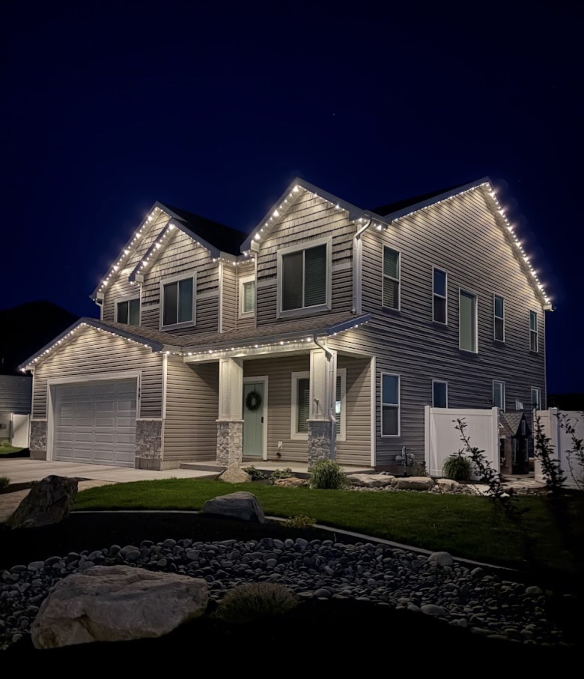 Warm white permanent lights outlining multiple residential gables