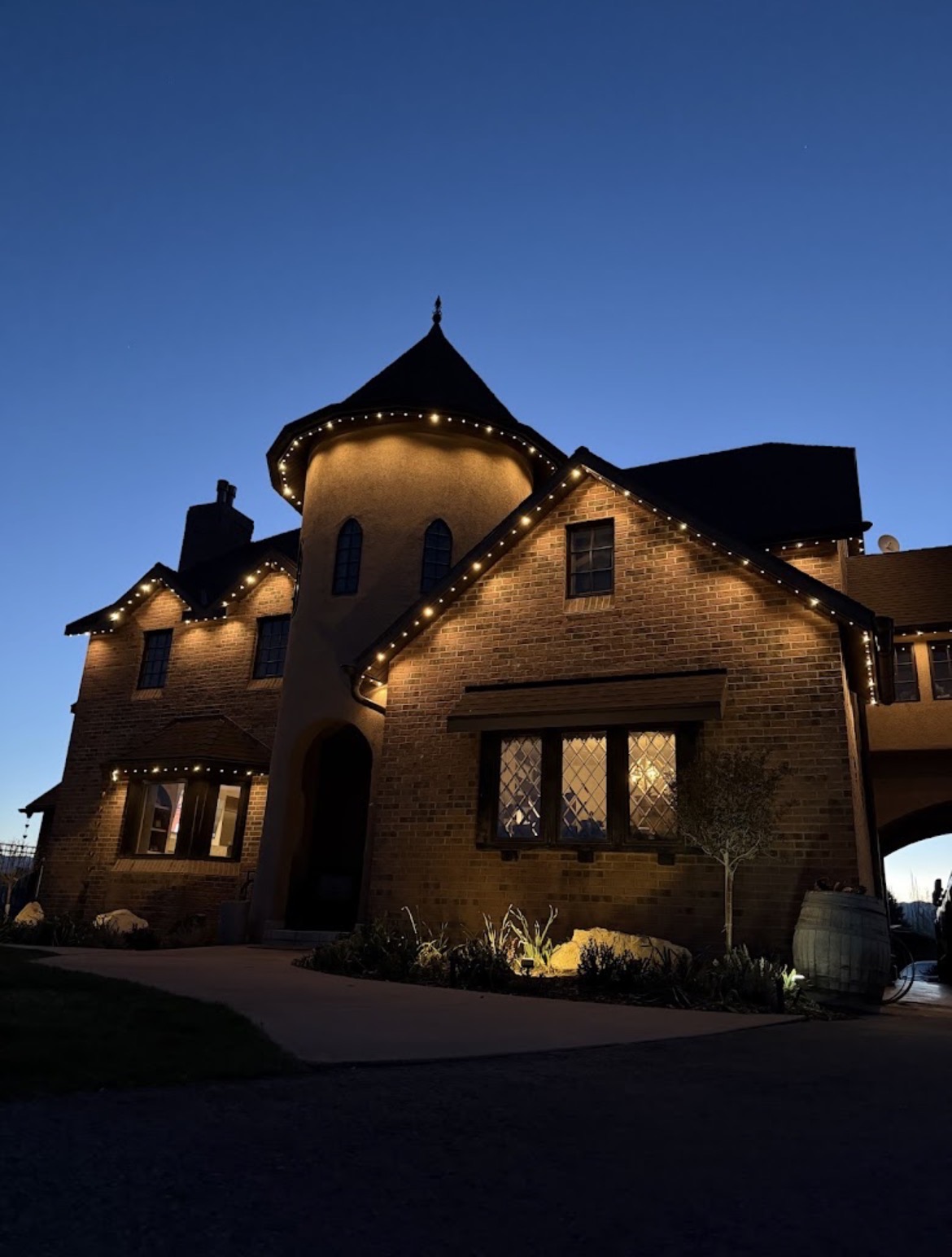 Warm-white permanent exterior lights installed along a residential roofline